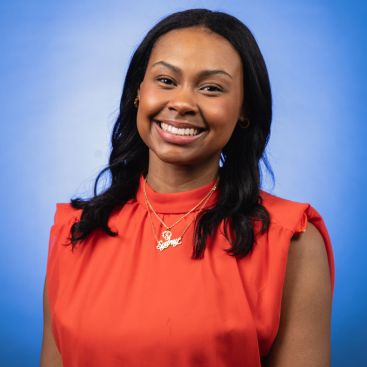 Headshot of Sydney Millage on a blue background