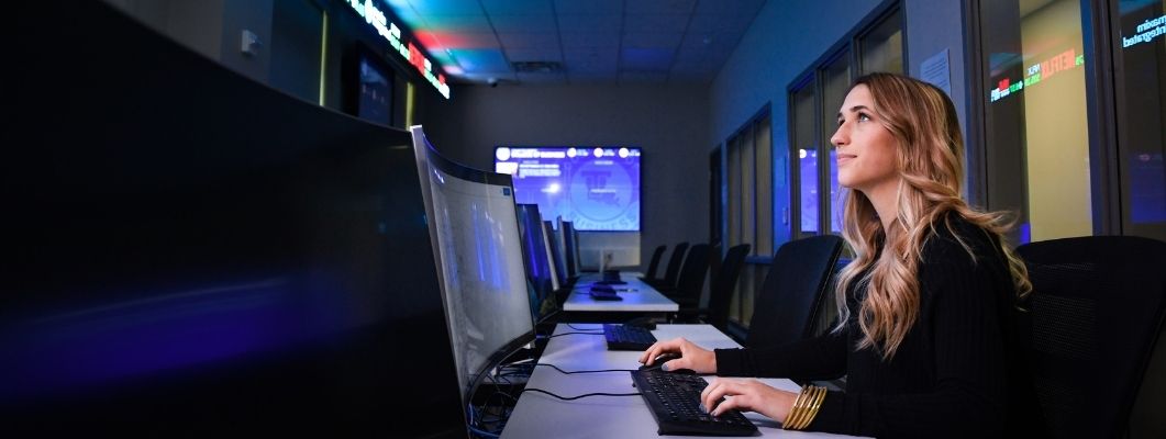 Female student working at a computer in Ray's Trading Room