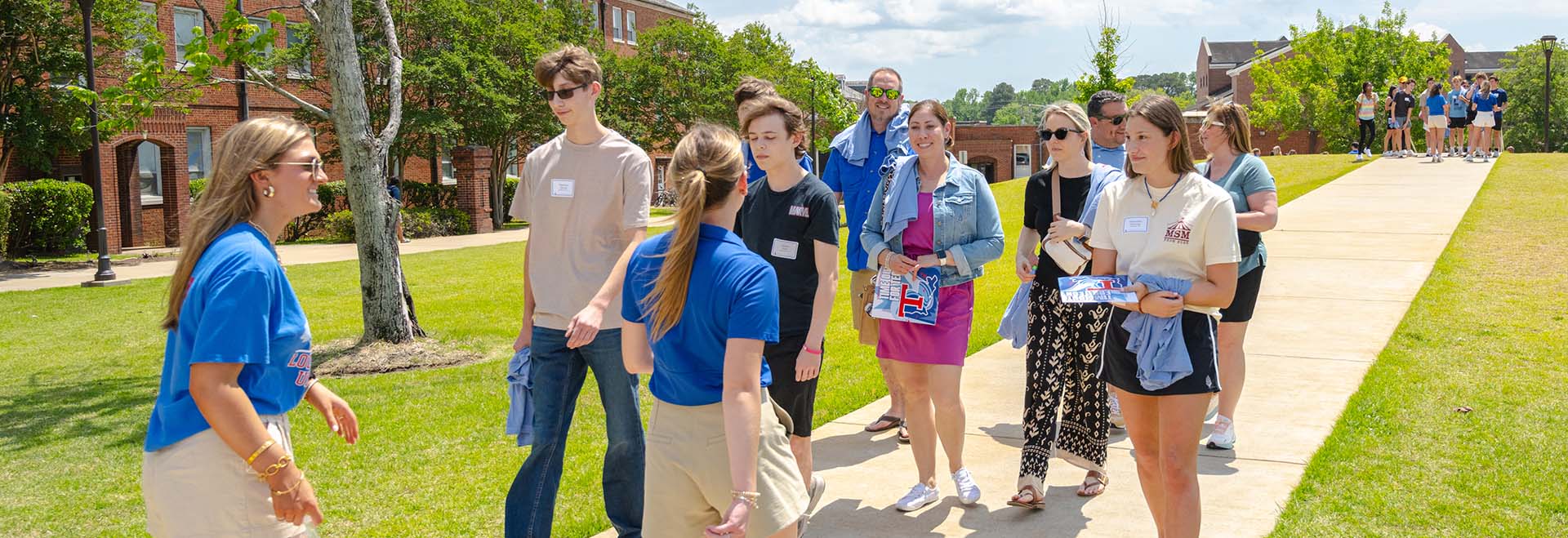 Recruiters give tours to prospective students and their families.