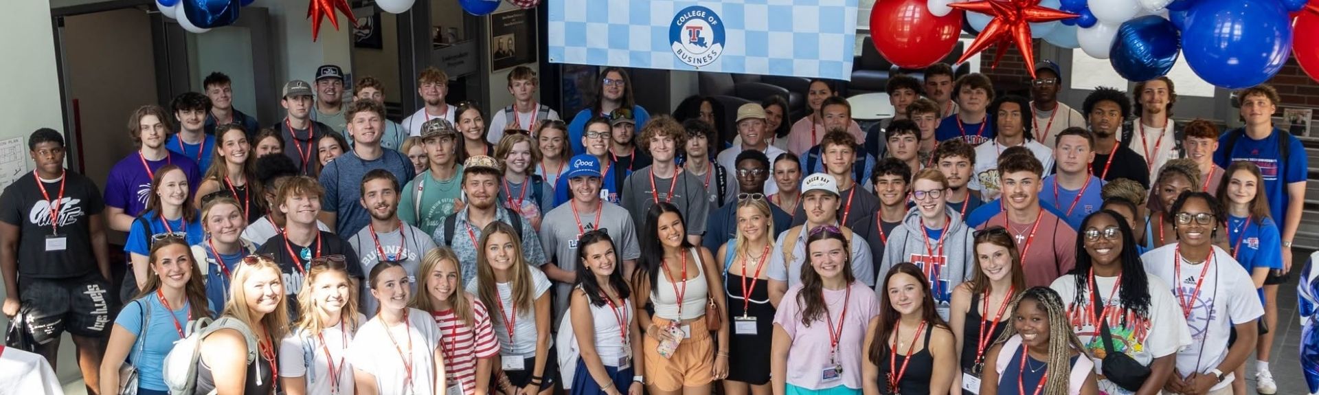 A group of incoming freshmen smile during orientation at the College of Business