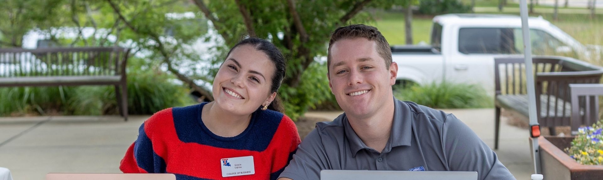 Two College of Business ambassadors work an event check in