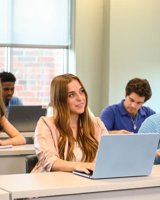 Female student in classroom with laptop