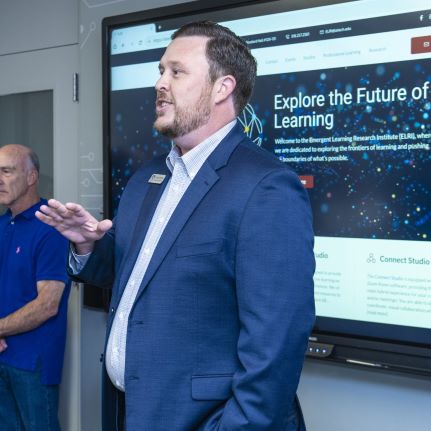 Dustin Whitlock is talking about learning, while standing in front of a Promethean board that is also talking about the Future of Learning.