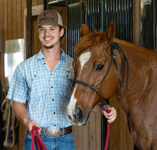 Student with horse in stable