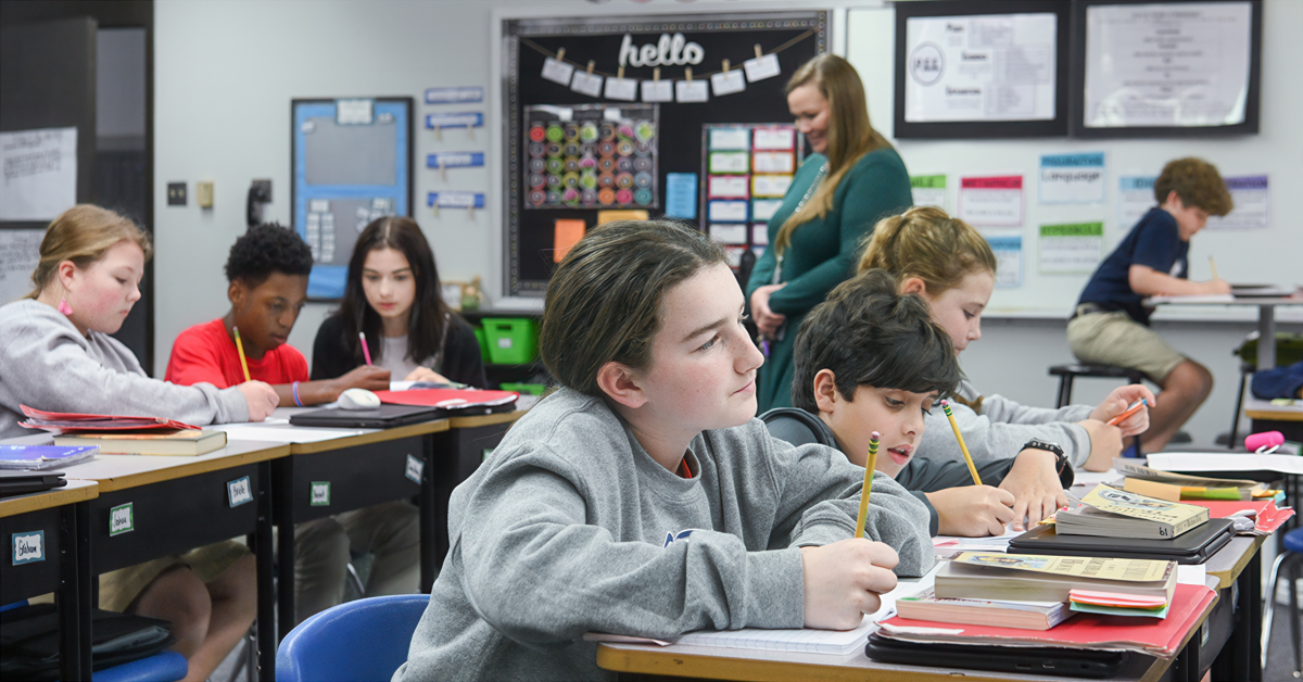 Students in an elementary classroom write at their desks