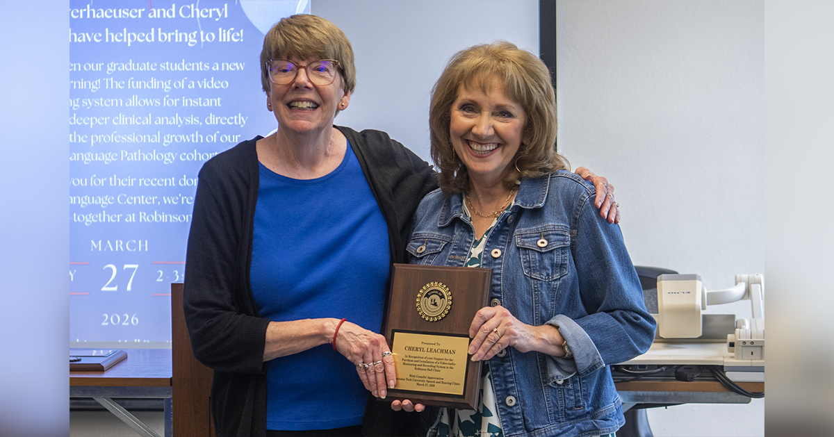 Dr. Brenda Heiman presents Cheryl Leachman with a plaque