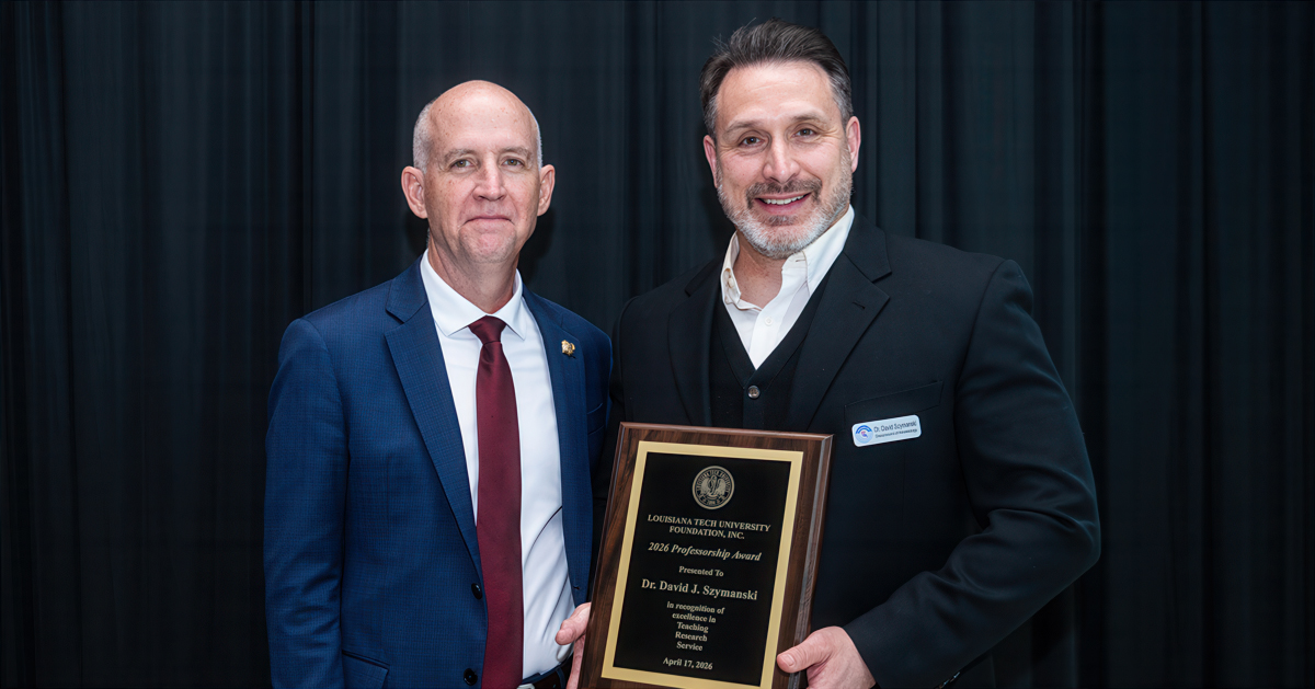 Dr. Dave Norris presents Dr. David Szymanski with a plaque