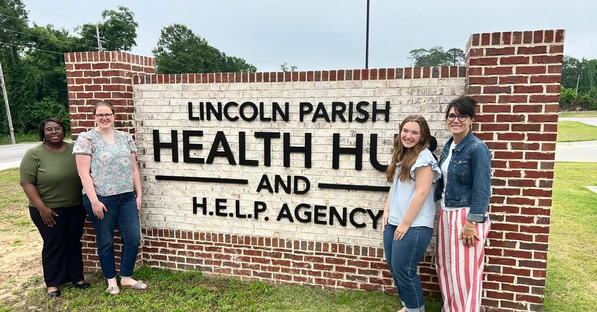 People stand near a sign that says 