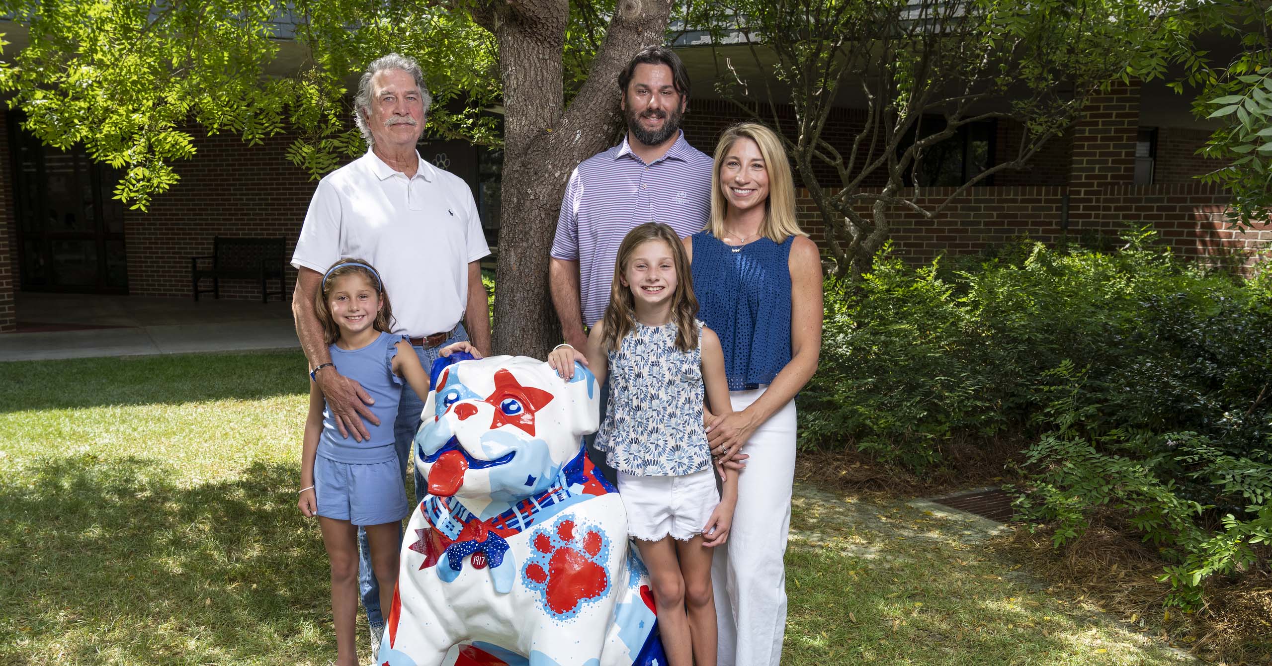 The Richardson family stands with the painted Bullpup statue on the A.E. Phillips campus