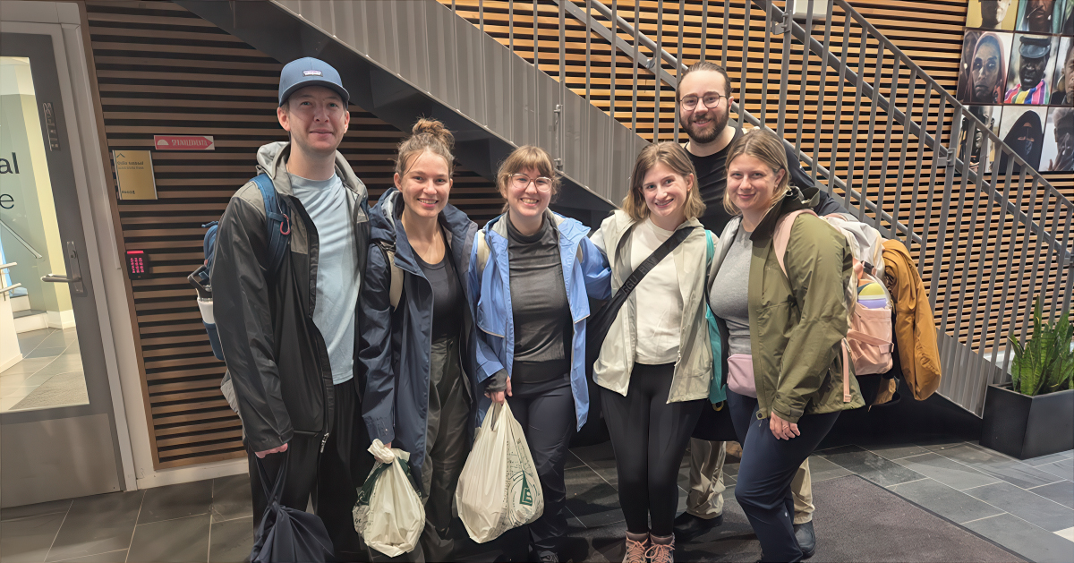 A group of college students stand together smiling