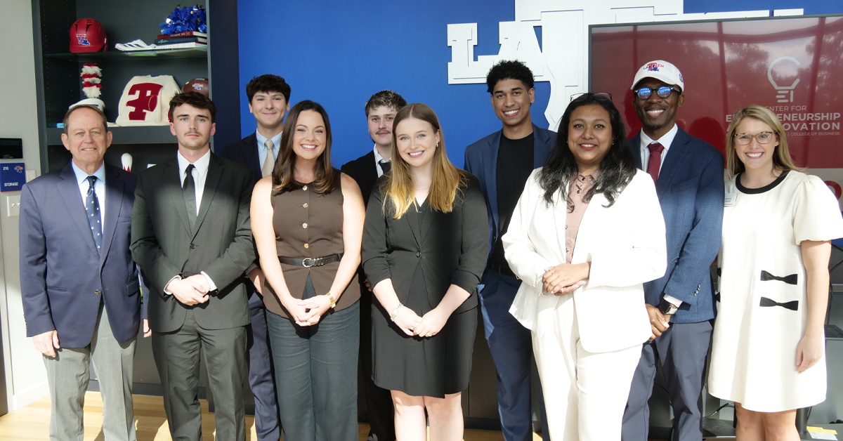 A group of people stand together smiling