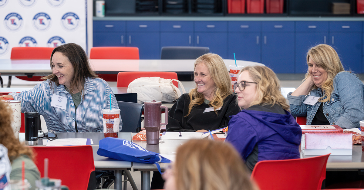 Women sitting around a table smile during a workshop