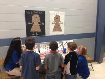 Nursing students Amanda Tham (far left) and Holly Sikes (far right) emphasize positive and negative words in their anti-bullying booth.