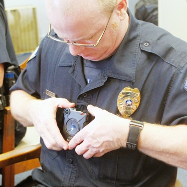 Louisiana Tech University Police Cpl. Allen Carnahan places his new department-issue body camera on his uniform. Tech police are now wearing the palm-sized cameras. Photo courtesy of Ruston Daily Leader.