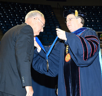 Benny Denny receives his Tower Medallion from Louisiana Tech President Les Guice.