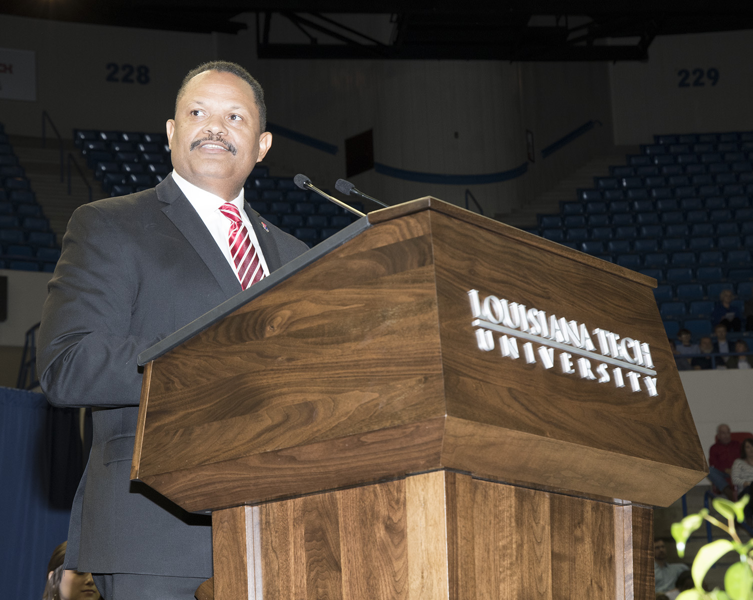 John Belton speaks at podium during commencement