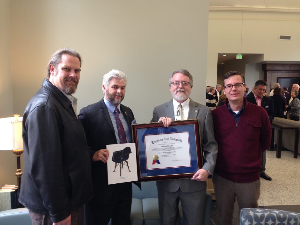 At a reception honoring his career upon his retirement in 2014, Jonathan Donehoo holds his framed document signifying his recognition as Professor and Director Emeritus of the School of Design. Pictured (from left)  are his former student and colleague Patrick Miller, Dean of the College of Liberal Arts Dr. Don Kaczvinsky, Donehoo, and Director of the School of Design Karl Puljak.