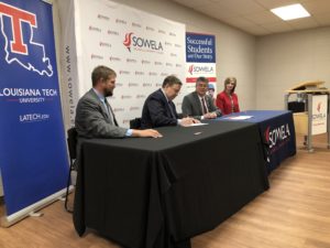 Leaders from both schools sign the MOU.