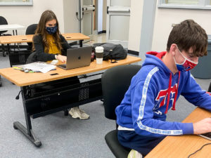 Students in a classroom and engaging in online debate contest.