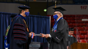 Joe Bates receives his diploma from Dr. Les Guice.