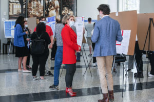 Students present poster on research to judges.