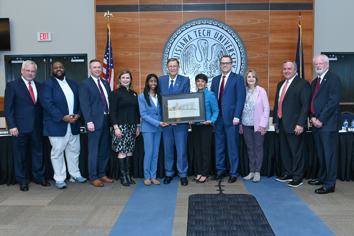 Board members display a rendering of the Biomedical Building.