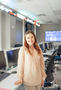 MBA student, Annaliese Russell, poses in Ray’s Financial Trading Room.