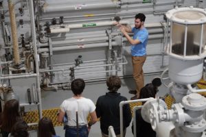 A Louisiana Tech student shows high schoolers how lab equipment works.